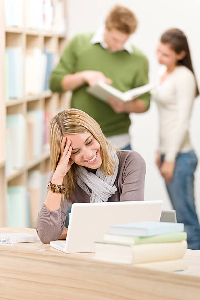 istock High school library - female student with laptop 153689840