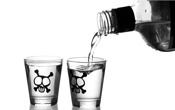 Shot of alcohol being poured into two shot glasses