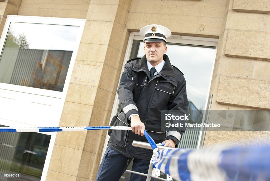 Un agente di polizia si piedi nel cordone di un'area - Foto stock royalty-free di Forze di polizia