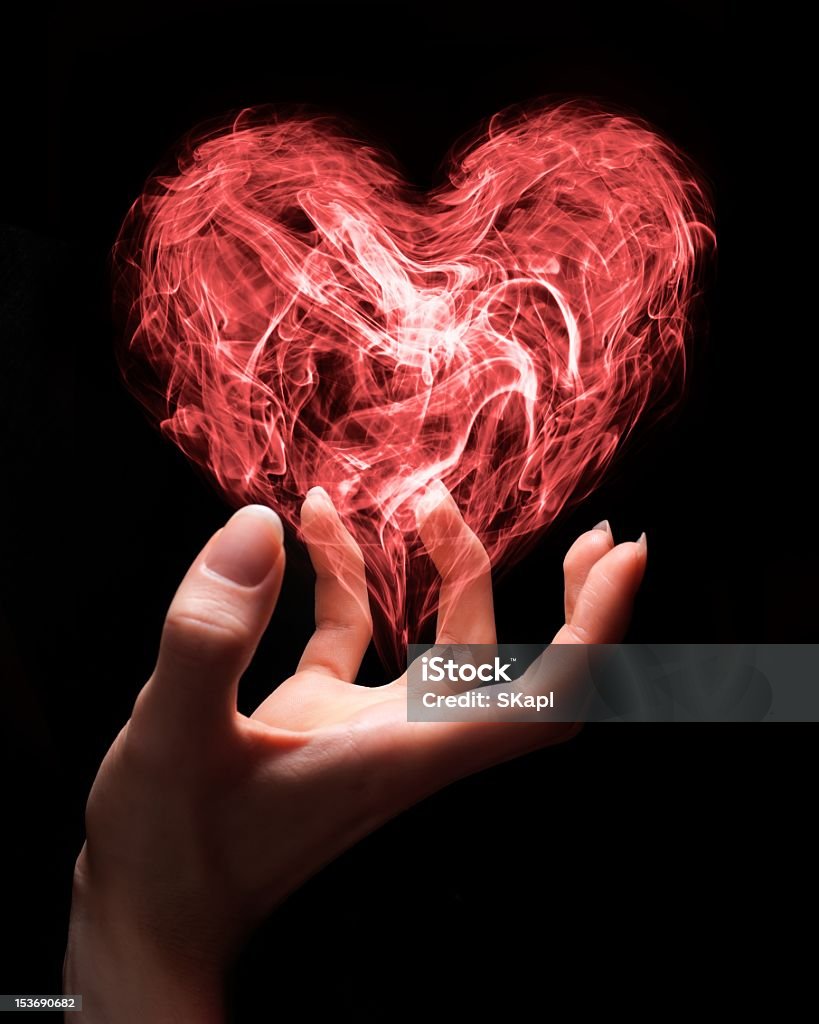 Fragile love Hand holding smoke heart as a symbol of fragile nature of love or can symbolize someone giving love. Abstract Stock Photo