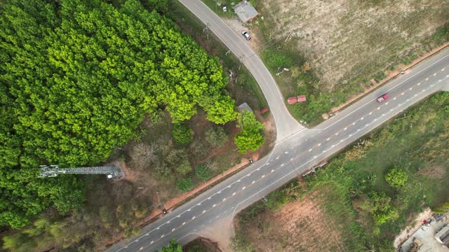 A pickup truck drives down a country road from aerial view