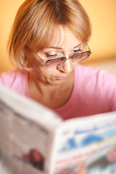 Woman reading a newspaper stock photo