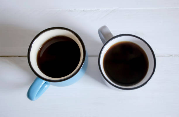 two cups of coffee on a white wooden table. americano for two. white wood and two cups of coffee. - isolated on white breakfast cafe office imagens e fotografias de stock