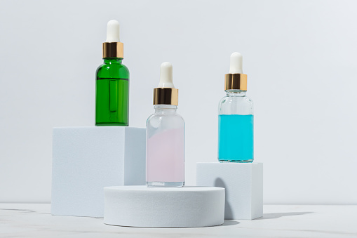Three different cosmetic serum dropper bottles 3D render, care product packaging for design and branding mockup