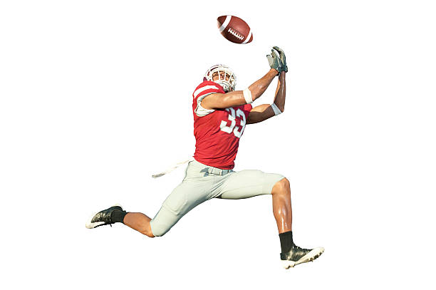 Football Player Catching a Ball Football player catches ball in midair. american football player stock pictures, royalty-free photos & images