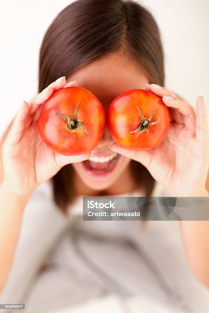 Tomatoes Woman Tomato. Woman showing tomatoes. Cute funny image of girl holding tomatoes in front of her eyes. Humor Stock Photo