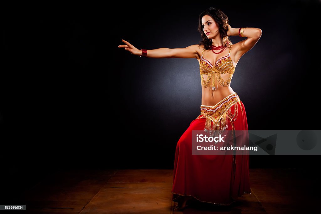 A belly dancer in traditional clothing in a dark studio A portrait of a beautiful belly dancer Belly Dancing Stock Photo