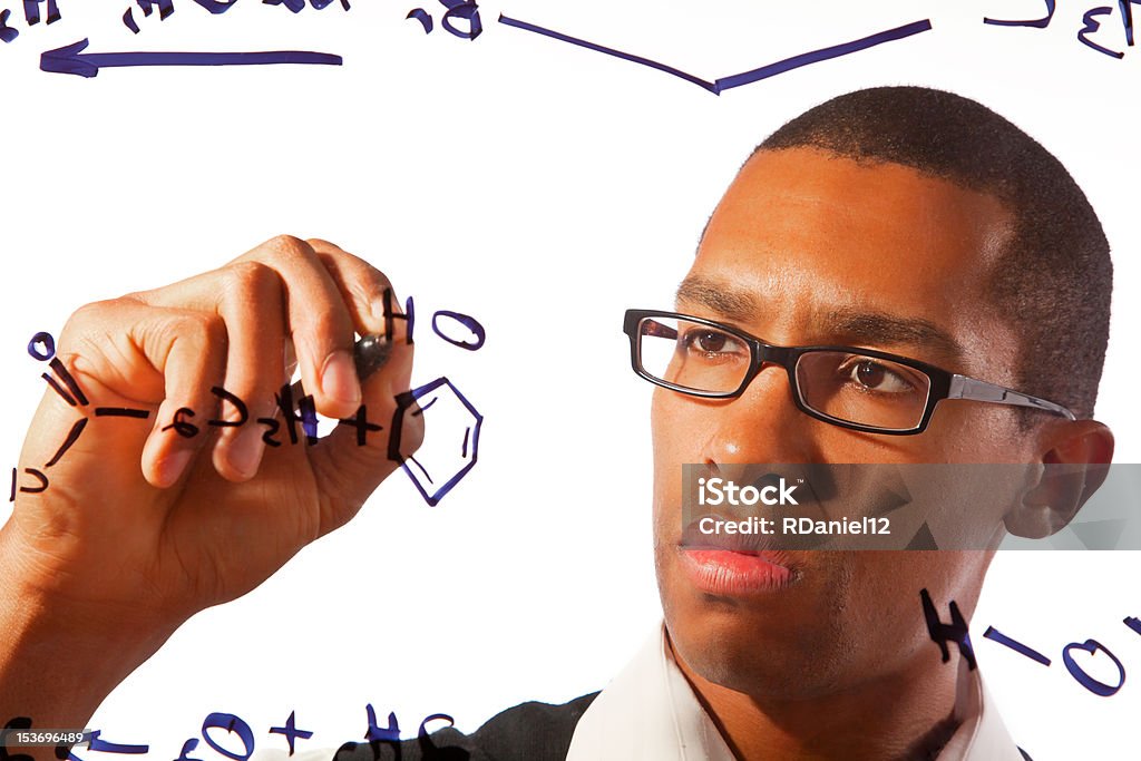 Student working on an equation A young man works on a chemistry problem. Adult Stock Photo