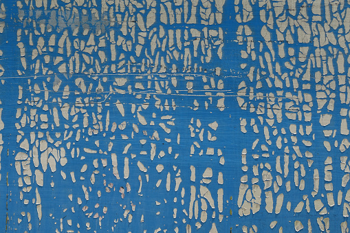 Cracked and weathered plastic wrap on metal surface. Abstract shapes grungy background.