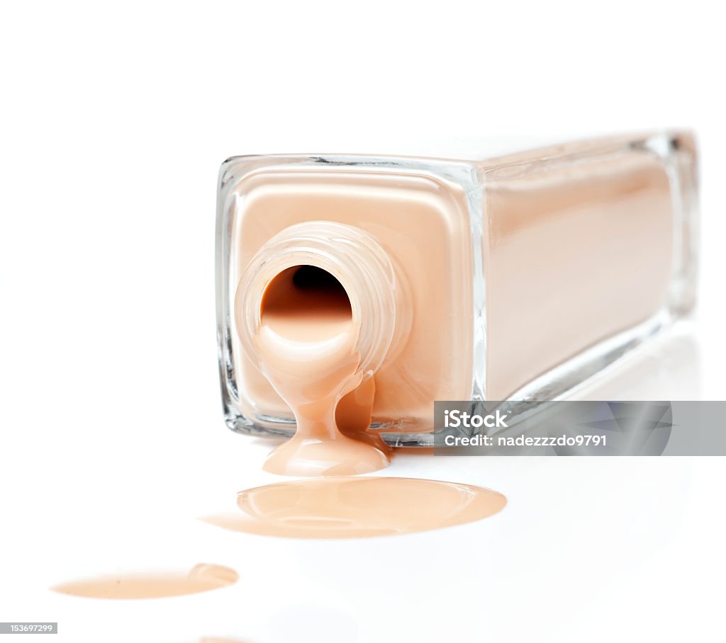 Bottle of foundation spilling on white table foundation on a white background Beauty Product Stock Photo