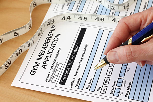 Hand with Pen completing a Gym Membership Application Form stock photo