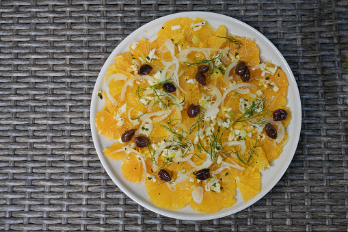 Orange salad with olives, onions and herbs, Italian summer dish from Sicily high angle view from above, copy space, selected focus