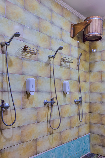 Shower Cabins in Banya Or Bath Interior with Bucket of Cold Water for Dousing.Vertical image