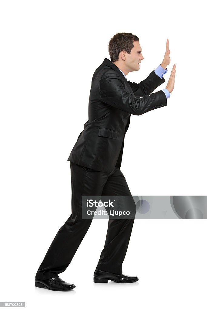 Full length portrait of a businessman pushing something Full length portrait of a businessman pushing something imaginary isolated on white background Activity Stock Photo