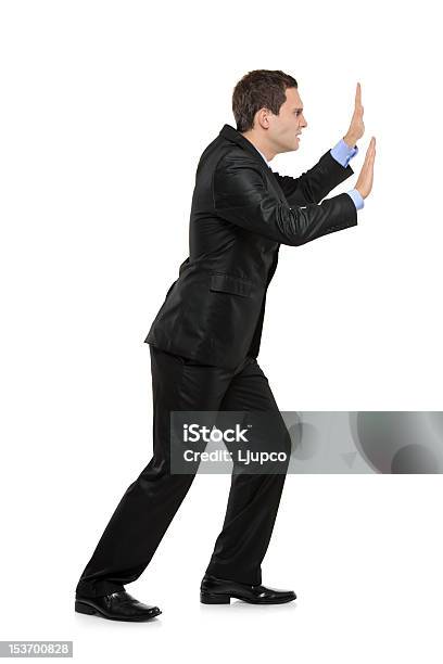 Full Length Portrait Of A Businessman Pushing Something Stock Photo - Download Image Now