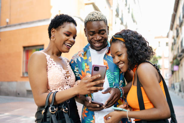 istock Three friends using smartphone in the street 1537010842