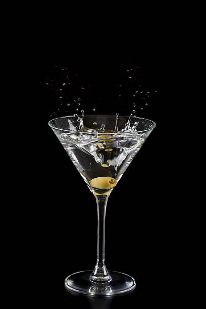istock An olive splashing into a martini glass on black background 153701204