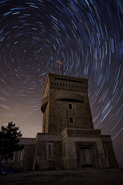 Tower under the sky during a star trail stock photo