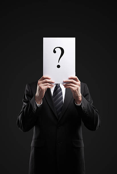 istock businessman holding a question mark on black background 153701288