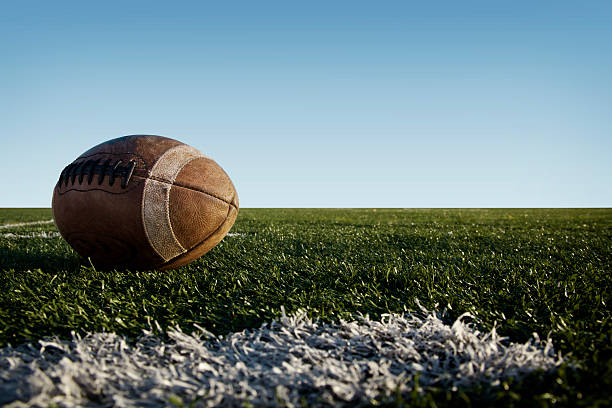 Football on a football field with a blue sky background stock photo