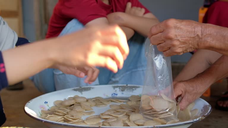 Workers pack traditional fish crackers in clear plastic packages