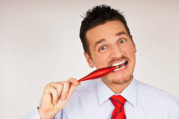 istock Young man bites into Christmas ornament 153703023