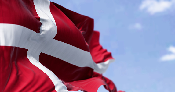 Denmark national flag waving in the wind on a clear day. The Kingdom of Denmark is a Nordic country in Northern Europe. Fluttering fabric. 3d illustration render. Selective focus