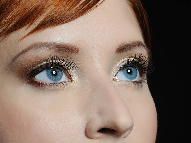 macro shot of blue eyes with long lashes and make-up stock photo