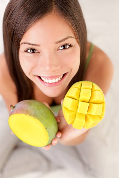mango frucht frau glücklich - dieting front view vertical lifestyles stock-fotos und bilder