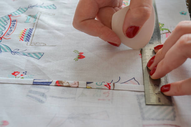 istock woman seamstress makes pattern with chalk on fabric for sewing clothes 1537033397