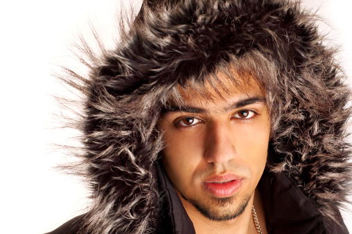 portrait of handsome young man in hooded parka with fur