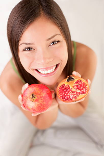 donna di frutta melograno - women smiling mature adult portrait foto e immagini stock