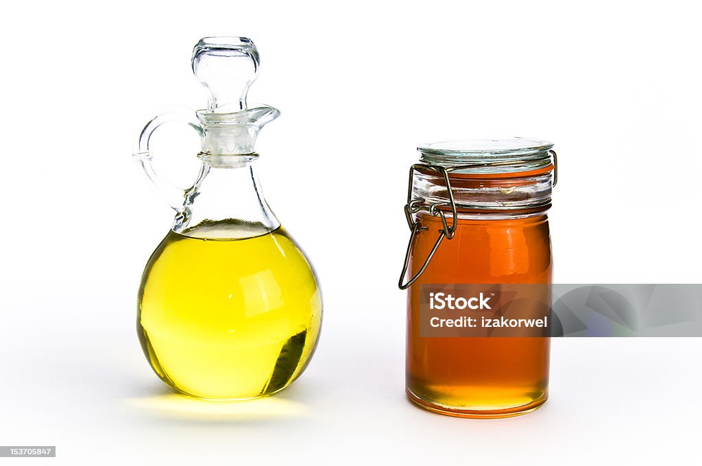 Le gustan los recipientes de vidrio y aceite de miel sobre fondo de aislamiento - Foto de stock de Aceite para cocinar libre de derechos