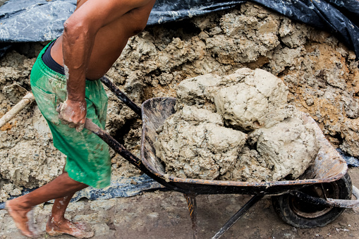 Aratuipe, Bahia, Brazil - August 31, 2018: Potter loading the dough into the wheelbarrow. Maragoipinho, city of Aratuipe, Bahia.