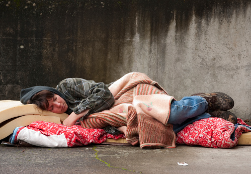 Homeless woman lying on the street.