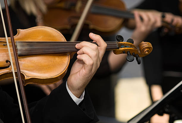 istock Musicians playing violins in the orchestra 153707603