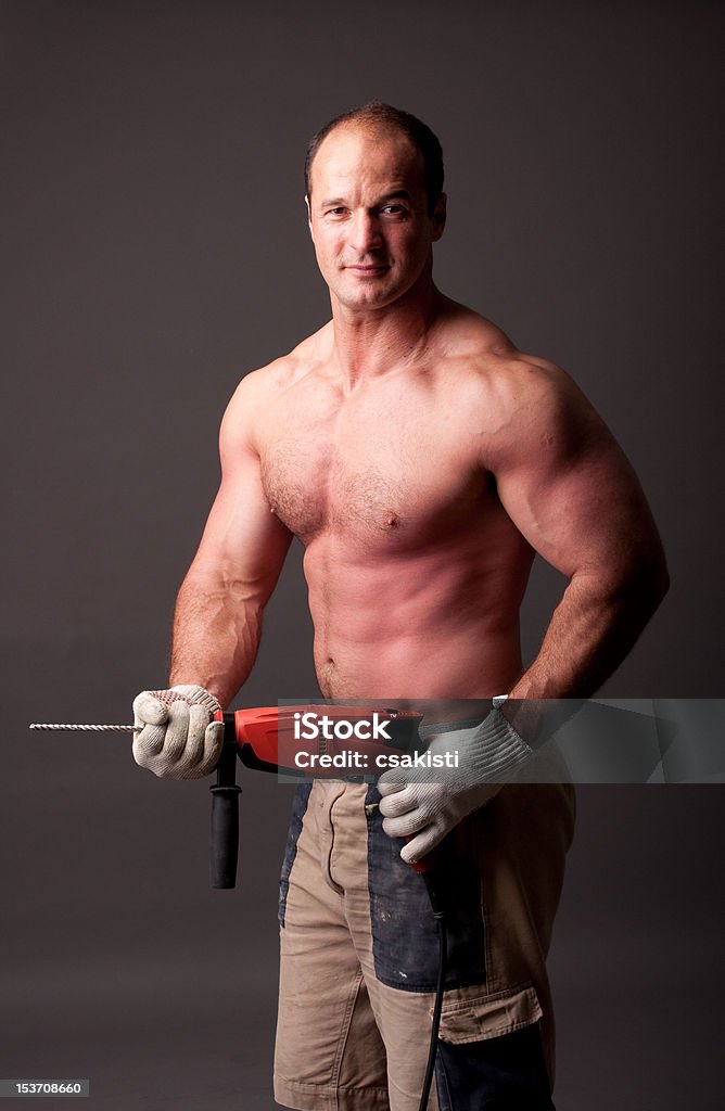 muscular construction worker muscular construction worker with drill Mechanic Stock Photo