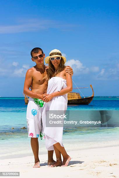 Junges Paar Am Strand Auf Den Hintergrund Der Jacht Stockfoto und mehr Bilder von Aktivitäten und Sport