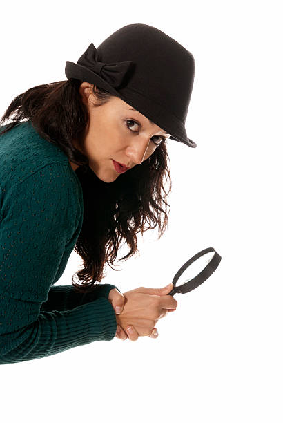 young woman with magnifier glass and hat looking to camera stock photo