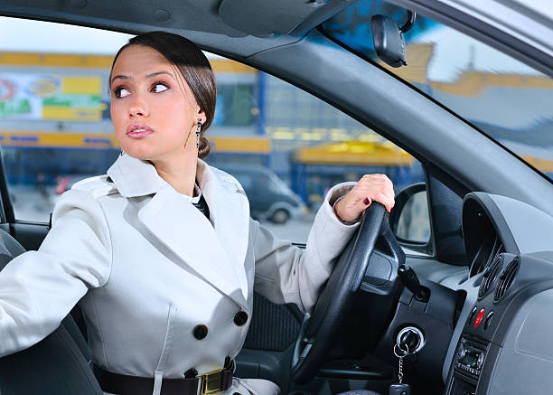 woman in a car is looking backwards stock photo