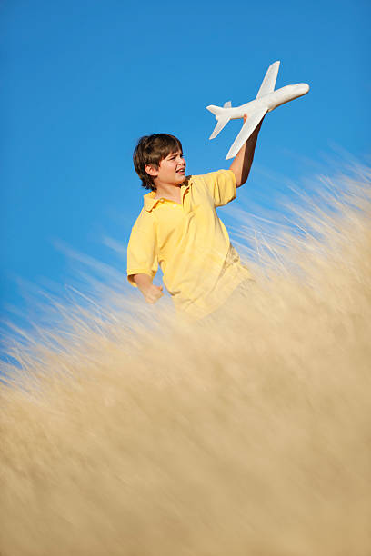 istock Young Boy Playing with Toy Glider Airplane in Grassy Field 153711174