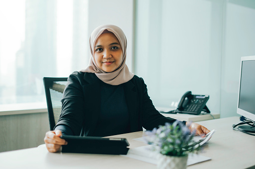 Asian Muslim woman working in the office