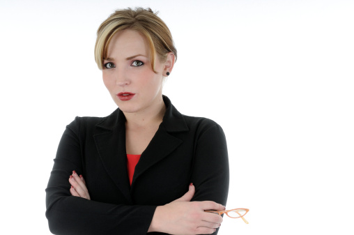 Portrait of an attractive female manager with staff members talking in the background. Selective focus on her. Studio shot with white background and copy space.