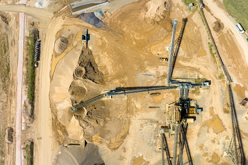 Gravel and sand open pit mining - aerial view, sandhills and conveyor belts