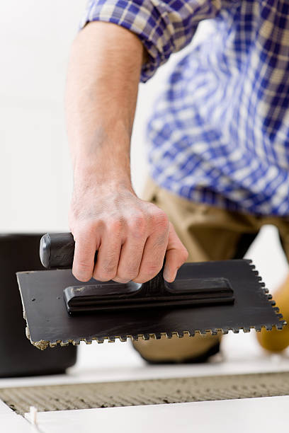 istock Home improvement - handyman laying tile 153712305