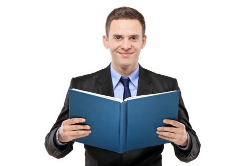 A young businessman reading a book isolated on white background