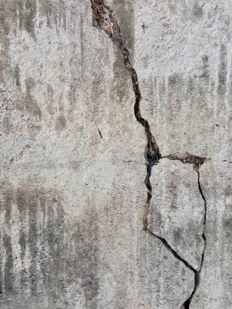 istock nailing on a concrete wall with a crack in the middle. 1537127517