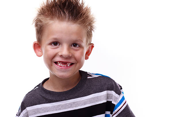 Cute young boy smiling and missing teeth stock photo