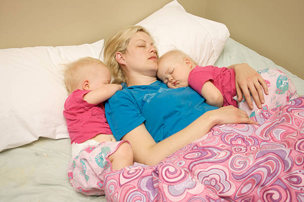 Mother and twins sleeping stock photo