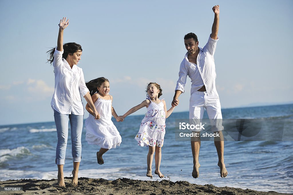 幸せな若い家族とビーチでの楽しいひととき - アクティブライフスタイルのロイヤリティフリーストックフォト